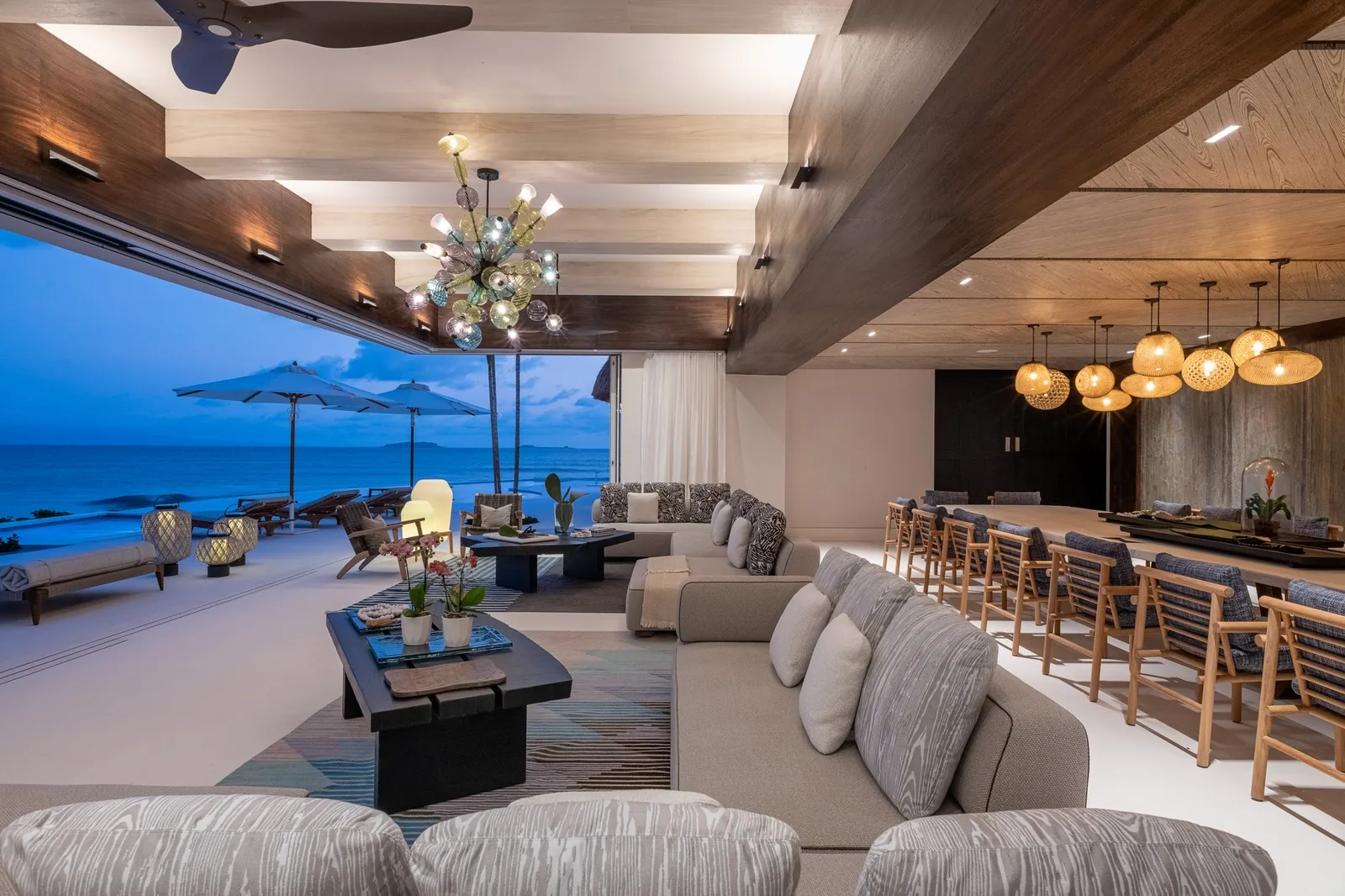 Casa Akai's living room at blue hour, the lights of the bay outside