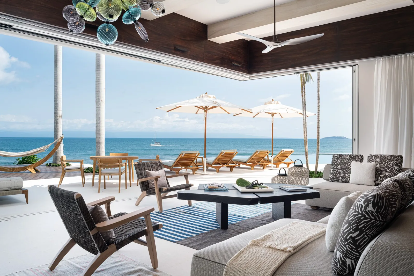 Casa Akai's living room with its glass walls open, one long space for a group to gather