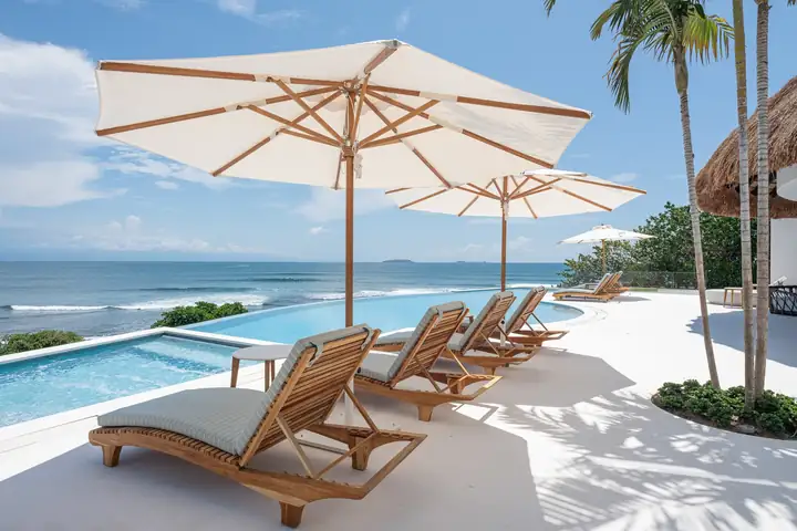 A long row of loungers under umbrellas at Casa Akai, enough for a big group